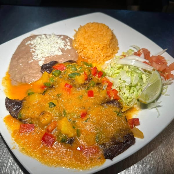 Javi Mexican Grill's mango fish with rice, refried beans, and a side salad with lime.