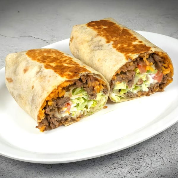 Two Javi Mexican Grill burritos, cut in half, revealing beef, rice, lettuce, and sour cream.